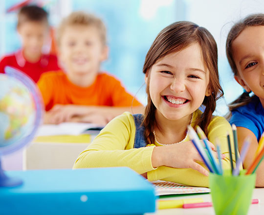 Niña sonriente en el salón de clase